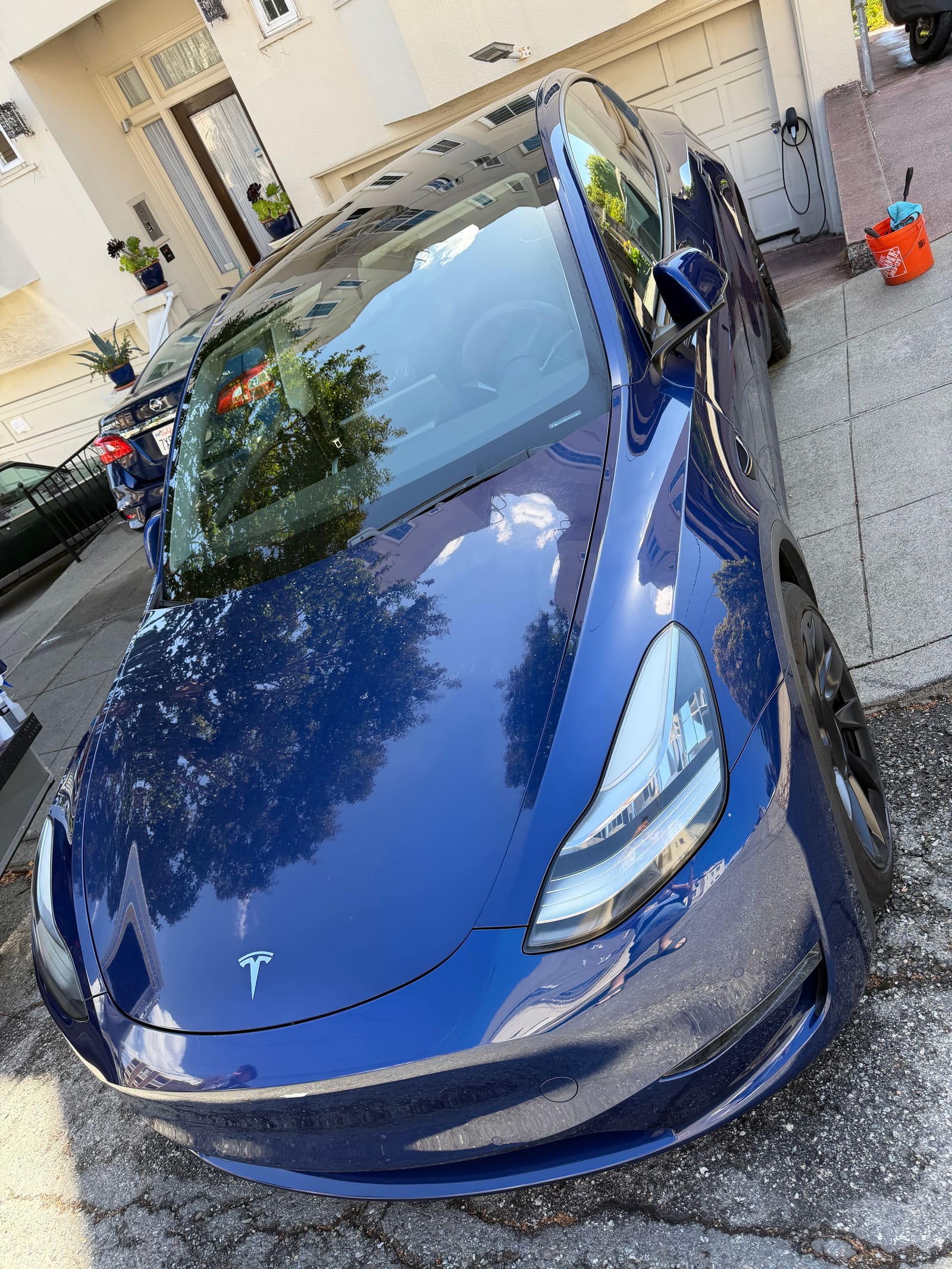 Dark blue Tesla Model 3 seen over the bonnet after a detail