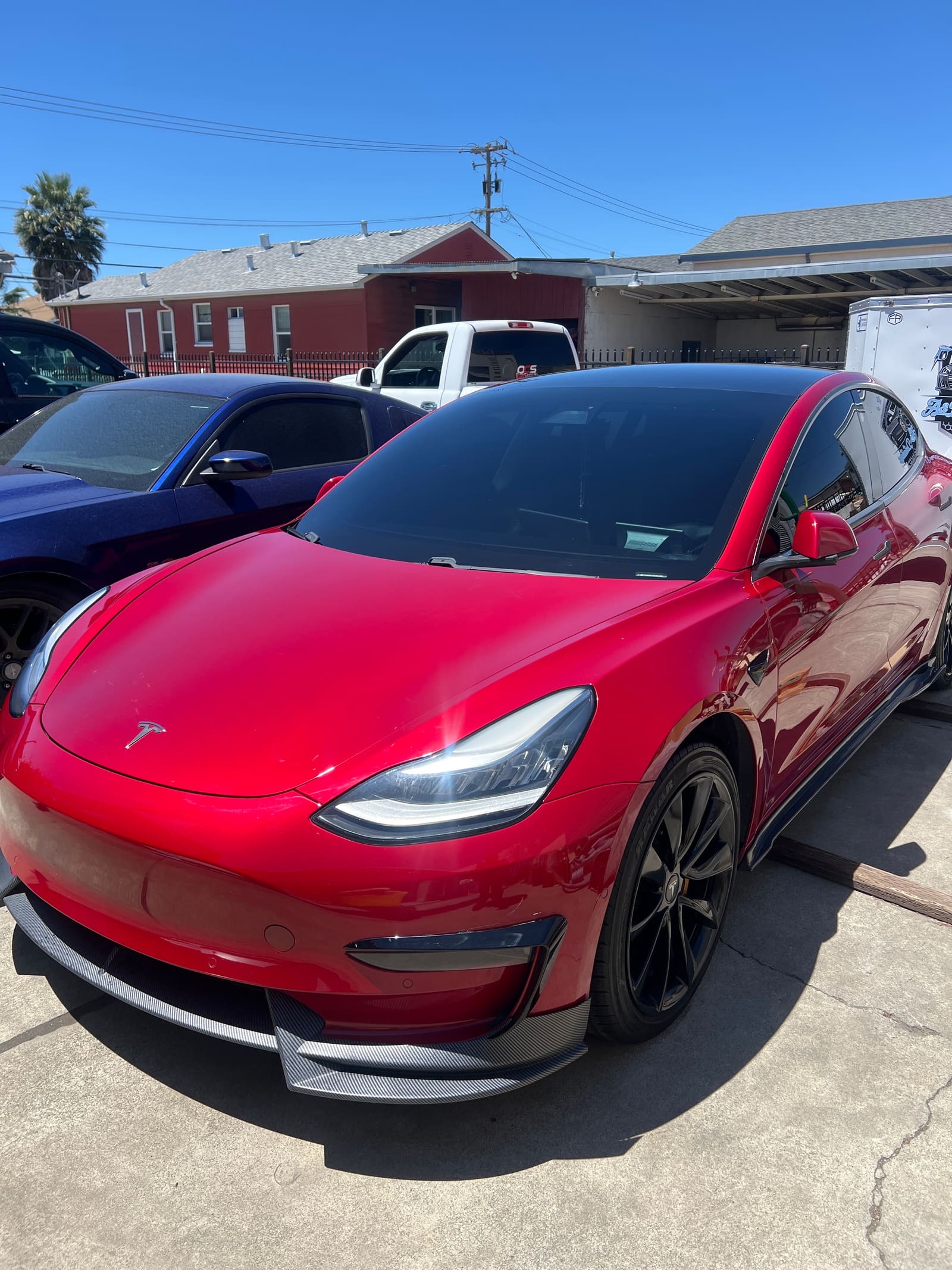 Red Tesla Model 3, front three-quarter, freshly detailed